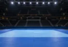 試合前の誰もいない柔道会場の青い畳と照明のイメージ
