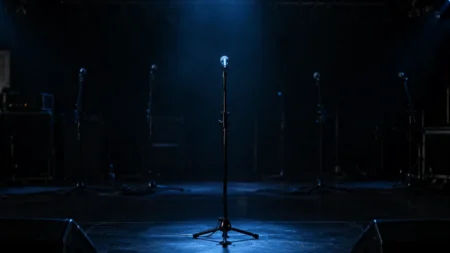 照明の落ちたライブステージに置かれたスタンドマイク
