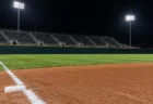 夜の球場の左翼スタンドと照明に照らされた外野フェンス