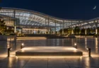 夜の駅前広場に照らされた展示スペースと三日月