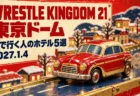 WRESTLE KINGDOM 21 東京ドーム 車で行く人のホテル5選 2027.1.4の文字と、冬の街並みを走る赤と金のブリキのおもちゃの車を描いたイラスト