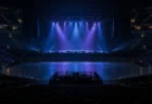 開演前の照明が落ちた無人の大型コンサートアリーナとステージのスポットライト
