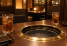 夜の焼き肉店のテーブルと網、2つのグラス
