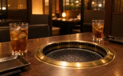 夜の焼き肉店のテーブルと網、2つのグラス