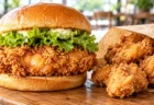 木のテーブルに置かれたフライドチキンを挟んだハンバーガー